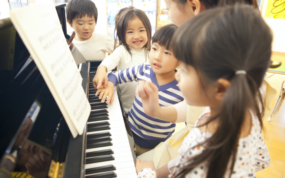 ピアノの周りに集まる子供